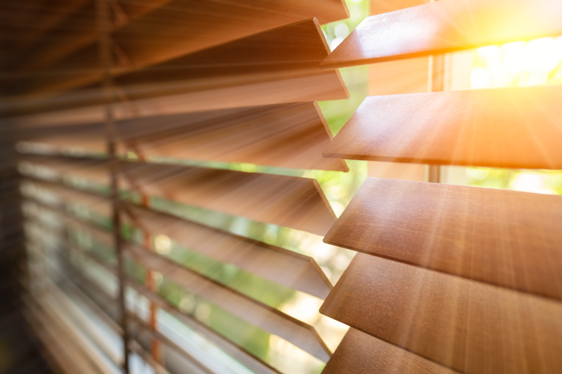Wooden venetian blinds filtering warm sunlight into a room