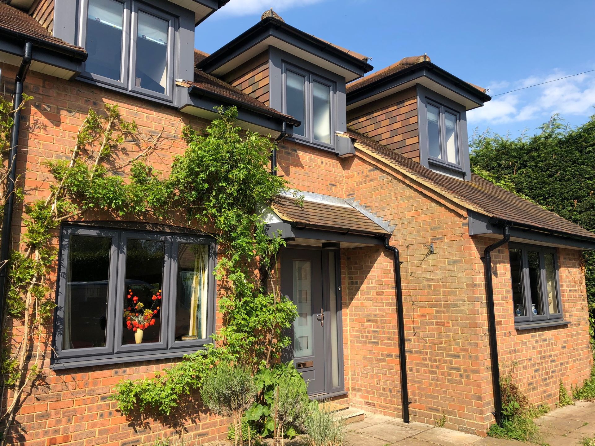 Grey casement windows and matching door on a brick Aylesbury home